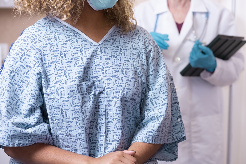 Young woman prepares for a breast exam, mammogram from her gynecologist doctor at hospital.