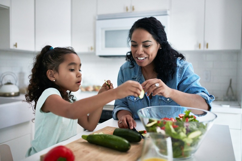 Mom and daughter preparing a healthy meal together.