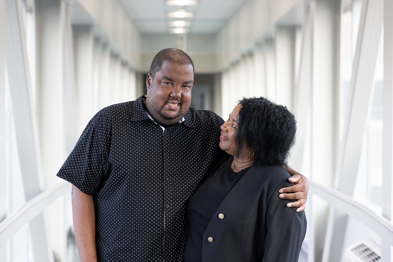Dave Ferguson standing, embracing a loved one and smiling.