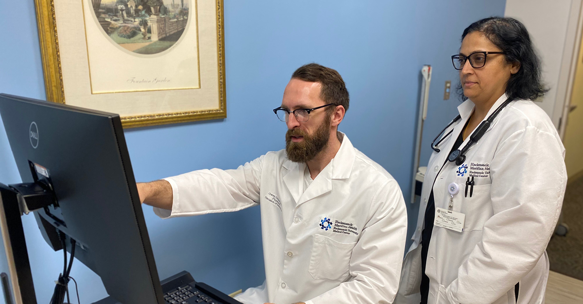 two physicians talking in front of computer
