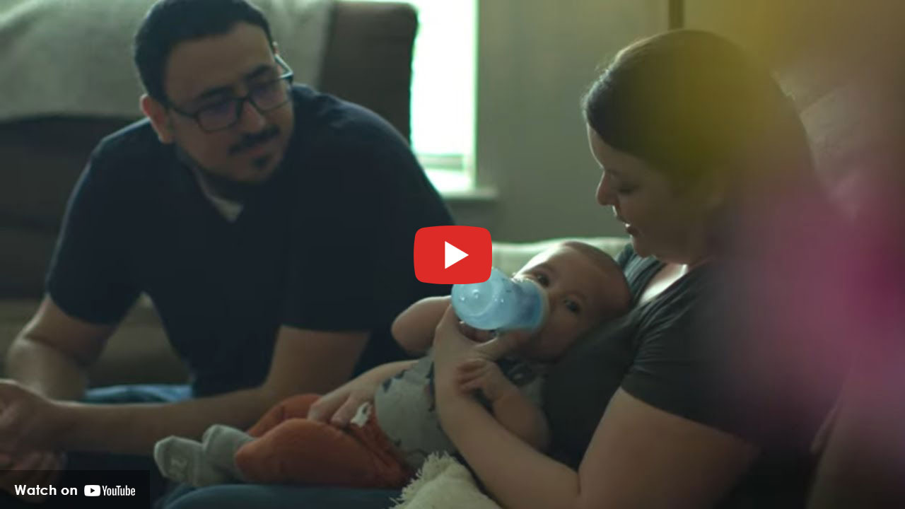 Parents feeding newborn at home