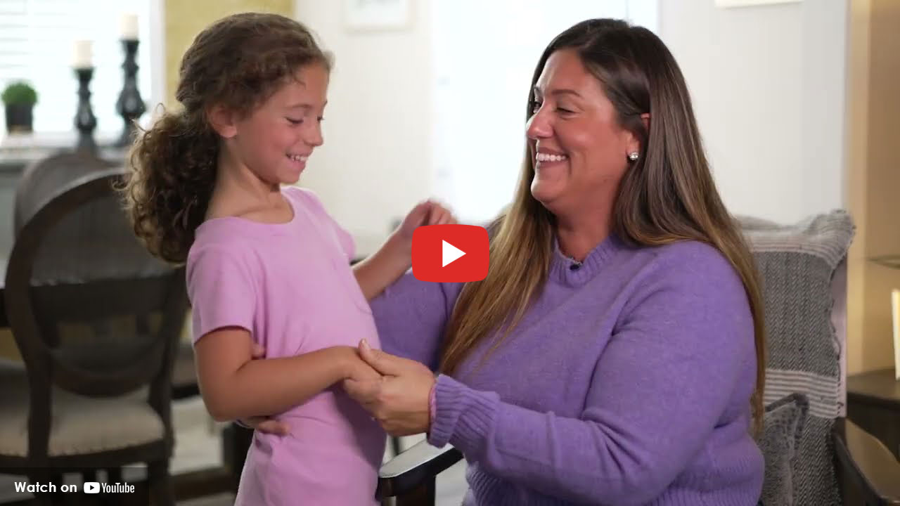 Mother and young child smiling together while holding hands indoors