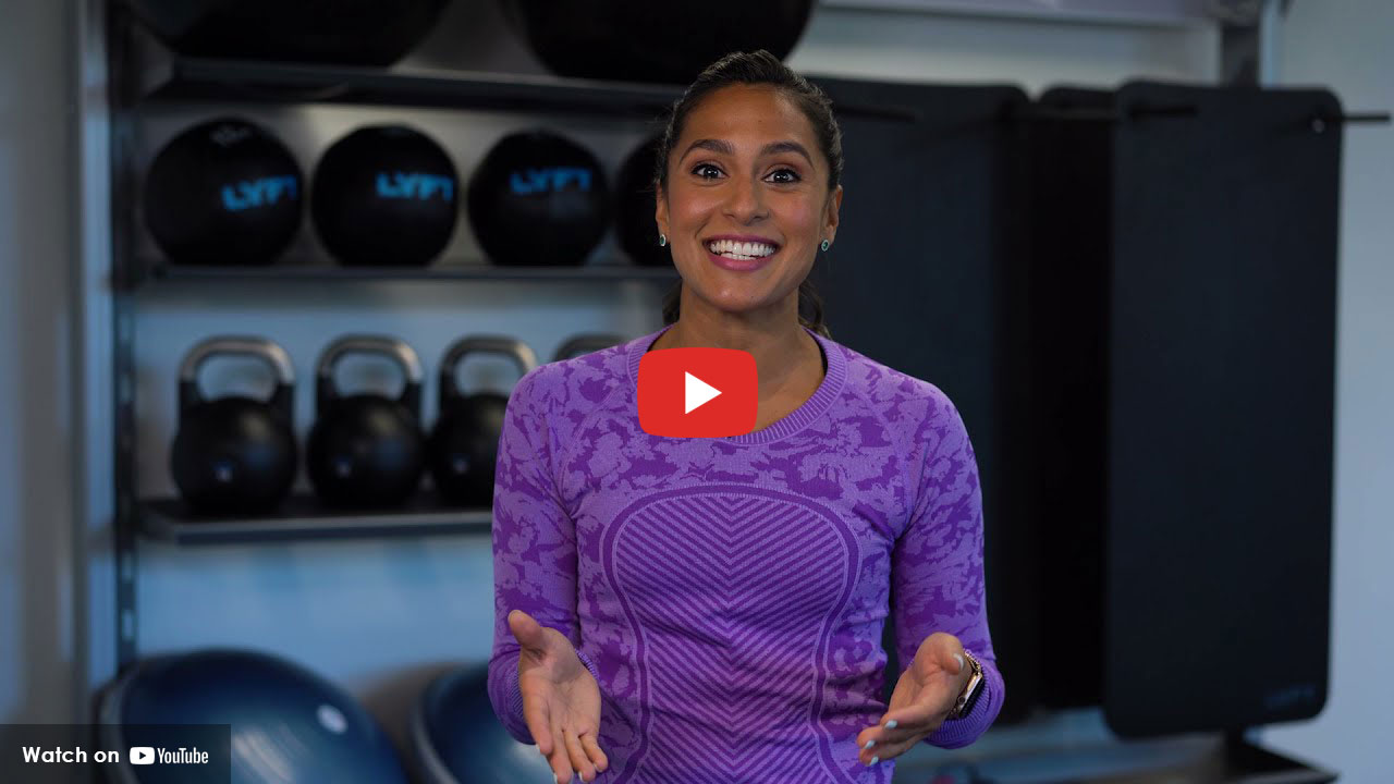 women in purple shirt standing in front of exercise eqipment
